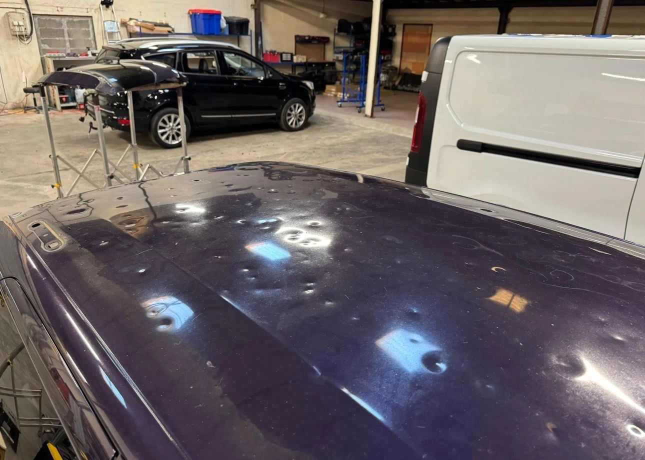 Voiture bleue toit grêlé